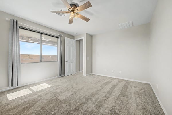 Bright and inviting primary bedroom offering abundant natural light, plush carpeting, ceiling fan, and a spacious layout. Designed to provide comfort while complementing the home's modern aesthetic.