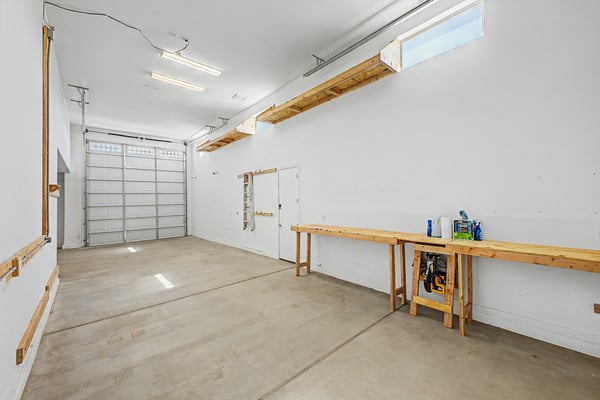 Spacious high-clearance RV garage featuring overhead storage, workshop space, and exceptional flexibility for recreational vehicles, boats, trailers, or additional household storage.
