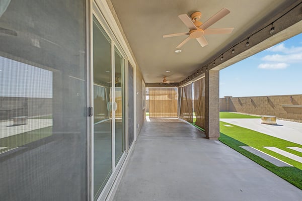Inviting covered patio with ceiling fans, recessed lighting, roll-down sun shades, and generous seating space. An ideal extension of the home's indoor living area for relaxing or entertaining in Wittman.