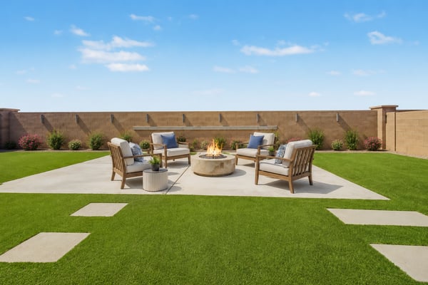 Virtually Staged Spacious outdoor entertaining area with artificial turf, a large concrete patio surrounding the fire pit, decorative wall feature, and plenty of room for outdoor furniture and gatherings.