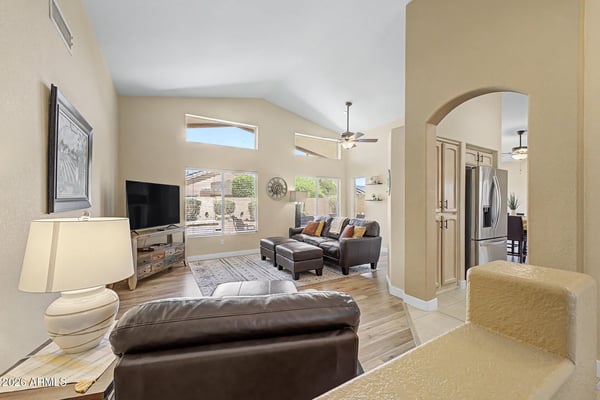 Large picture windows and soaring ceilings create an airy living space filled with natural light. The open design flows effortlessly into the kitchen, making everyday living both comfortable and inviting.