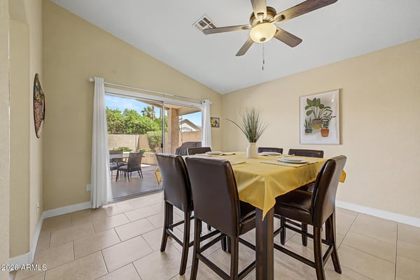 The dining area is filled with natural light and offers easy access to the covered patio through sliding glass doors. Tile flooring and an open layout make this an ideal setting for everyday dining and entertaining.
