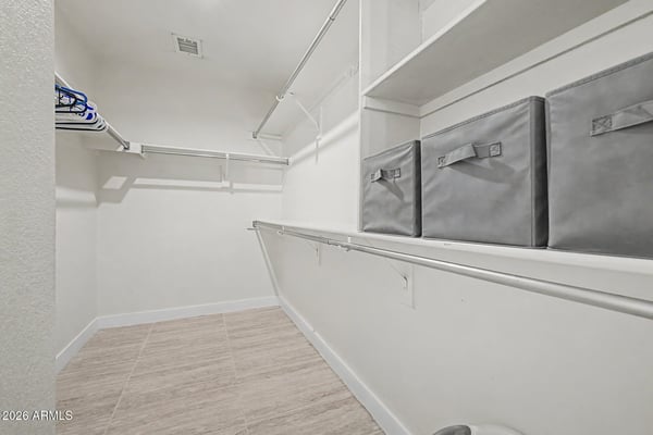 This spacious walk-in closet provides extensive shelving, hanging rods, and organized storage solutions for clothing, shoes, and seasonal items while complementing the home's functional layout.