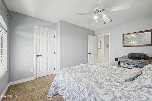 Comfortable and inviting, this secondary bedroom features soft carpeting, ceiling fan, neutral finishes, and excellent natural light. A flexible room that easily accommodates guests or everyday living.