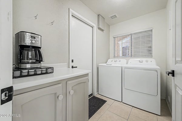 Complete with full-size washer and dryer, cabinetry, countertop space, and natural light, this dedicated laundry room offers convenience and efficiency for everyday household tasks.