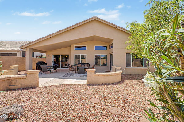 The backyard offers an expansive covered patio, mature landscaping, and easy-care desert landscaping designed for year-round enjoyment. Large windows and sliding glass doors create seamless indoor-outdoor living, making this Goodyear rental ideal for entertaining and everyday relaxation.