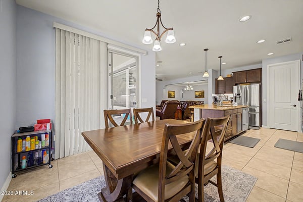 This inviting breakfast area features large windows, backyard views, and convenient access to outdoor living spaces. A perfect spot for dining while enjoying the home's bright, open design.