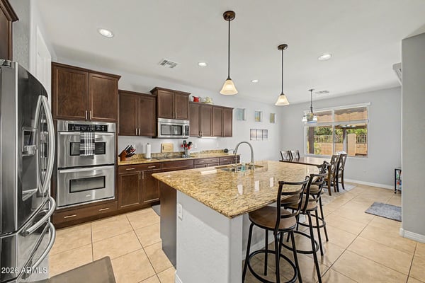 This thoughtfully designed kitchen showcases granite counters, quality stainless steel appliances, generous cabinet storage, and a large walk-in pantry, offering exceptional functionality for home chefs.