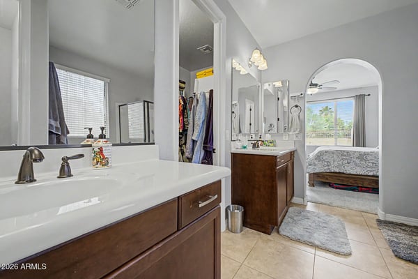 Dual vanities, abundant cabinet storage, and a walk-in closet make this primary bathroom both stylish and practical. Designed for comfortable daily living in this Goodyear rental.