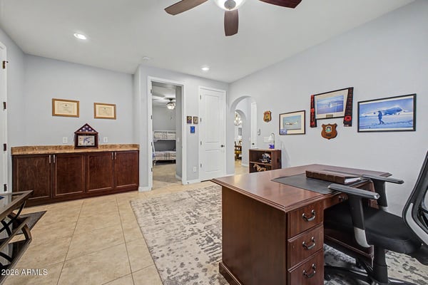 A second perspective showcases the generous layout, built-in storage, and multiple furniture options, making this bonus room perfect for working from home or relaxing in Goodyear.