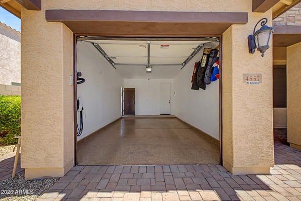 This oversized attached garage features epoxy-coated flooring, generous parking space, EV charging capability, and room for additional storage, offering everyday convenience in Goodyear.