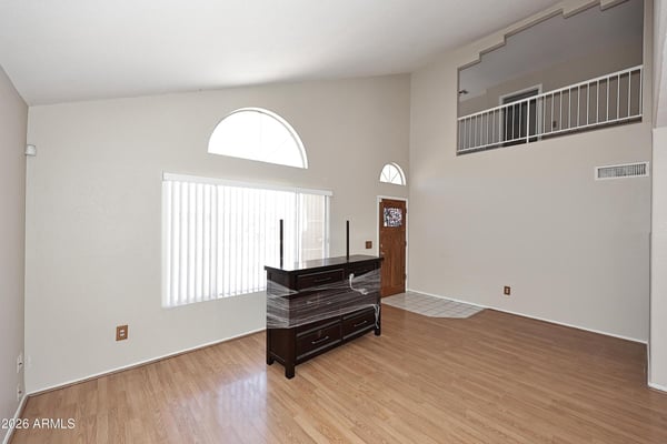 Spacious living area showcases impressive ceiling height, abundant natural light, updated flooring, and an open floor plan designed for modern living.