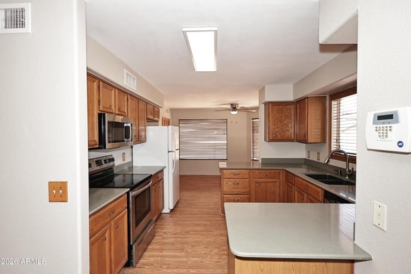 Functional kitchen features extensive cabinetry, breakfast bar seating, ample countertop space, and an open layout connecting effortlessly to the living areas.
