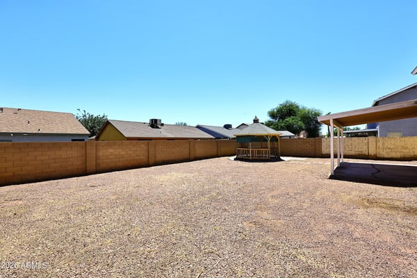 Large backyard provides abundant outdoor living space with privacy walls, easy-care landscaping, and endless possibilities for recreation.