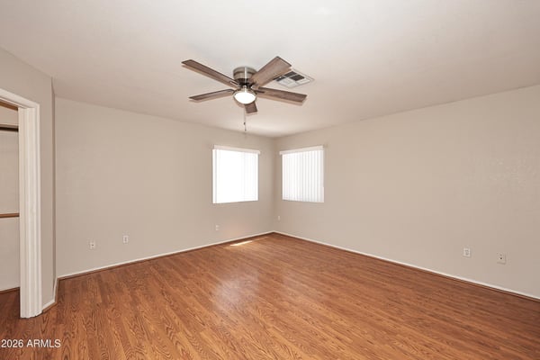 Inviting primary bedroom offers generous living space, updated flooring, multiple windows, and a relaxing atmosphere ideal for everyday comfort.