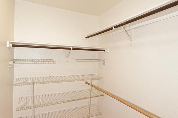 Walk-in closet provides extensive shelving, hanging rods, and ample storage space to help keep clothing and personal items neatly organized.