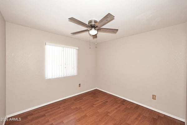 Comfortable secondary bedroom features updated flooring, ceiling fan, and flexible space perfect for guests, family, or a home workspace.