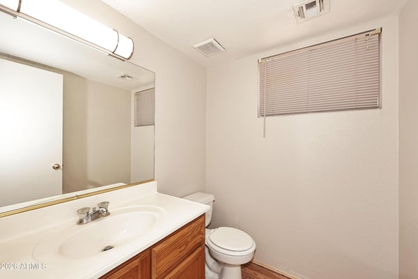 Convenient half bathroom includes a vanity with storage, oversized mirror, and easy access for guests and everyday household use.