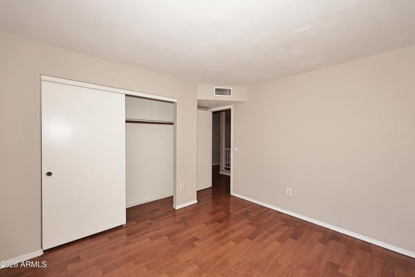 Spacious third bedroom features updated flooring, closet storage, and flexible living space that easily functions as a bedroom, office, or hobby room.