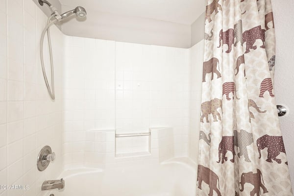 Full hall bathroom offers a tub and shower combination with built-in storage niches, providing convenience for everyday living.