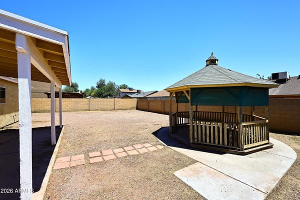 Spacious backyard showcases a charming gazebo, low-maintenance landscaping, and plenty of room for outdoor gatherings and relaxation.