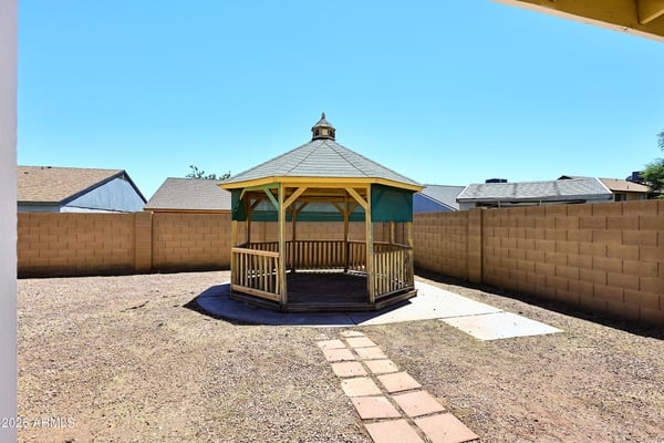 Attractive gazebo offers a welcoming outdoor gathering area surrounded by a spacious backyard designed for low-maintenance living.