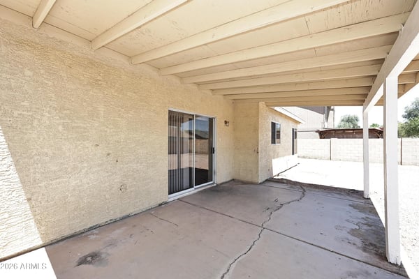 Covered patio provides comfortable outdoor living space with direct backyard access, making it perfect for relaxing or entertaining in Phoenix.