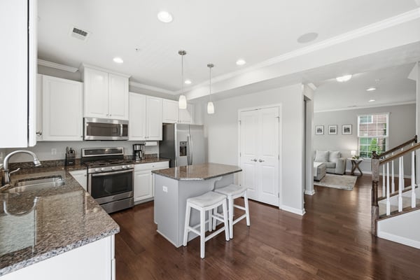 Modern kitchen with stainless steel appliances, a spacious island, and open layout connecting to the living area.
