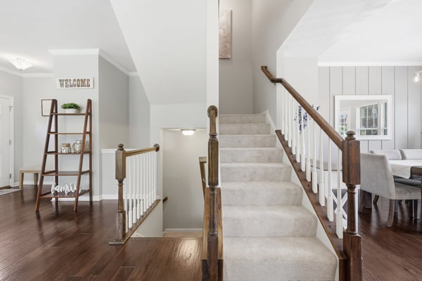 Bright and inviting foyer with staircase leading to spacious living areas and modern finishes throughout.