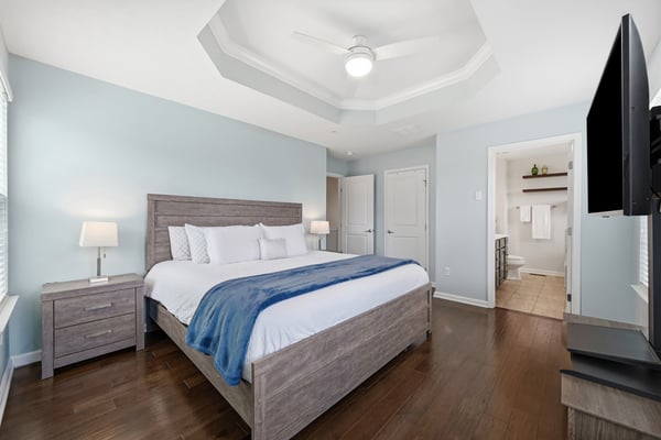 Spacious bedroom featuring a coffered ceiling, modern lighting, and a convenient en-suite bathroom.