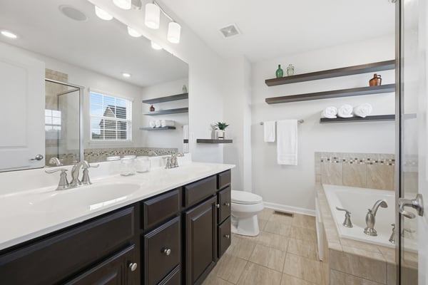This modern bathroom features dual vanities, ample storage, and a spacious layout for comfort and convenience.