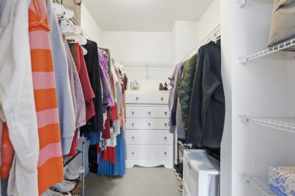 Spacious walk-in closet features ample storage with shelves and drawers, perfect for organization and easy access.