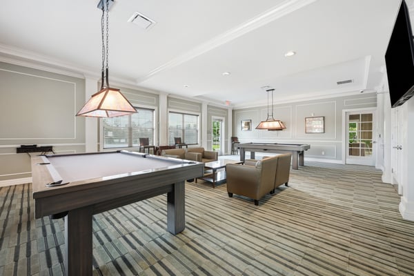 Spacious entertainment lounge featuring pool tables and ample seating, perfect for social gatherings and relaxation.