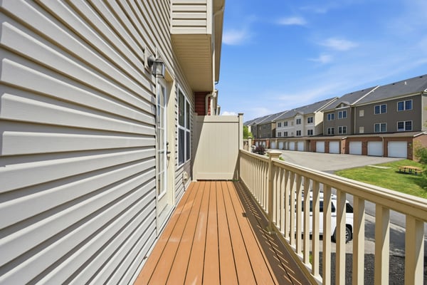 Spacious balcony with ample room for outdoor seating, overlooking a well-maintained community.