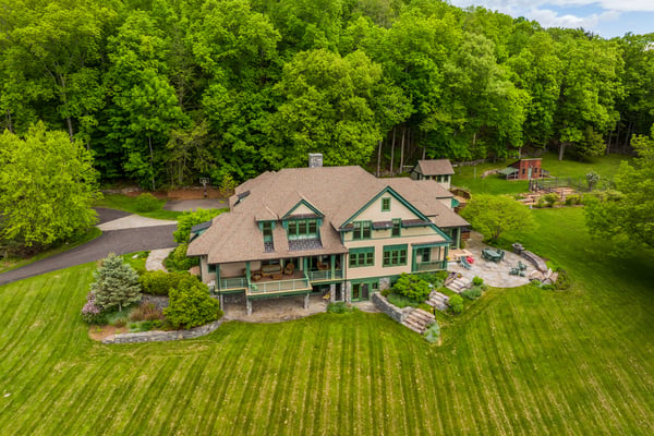 Expansive property featuring a spacious home surrounded by lush greenery and outdoor entertaining areas.