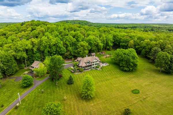 Nestled in lush greenery, this expansive estate features a spacious home and scenic outdoor spaces.