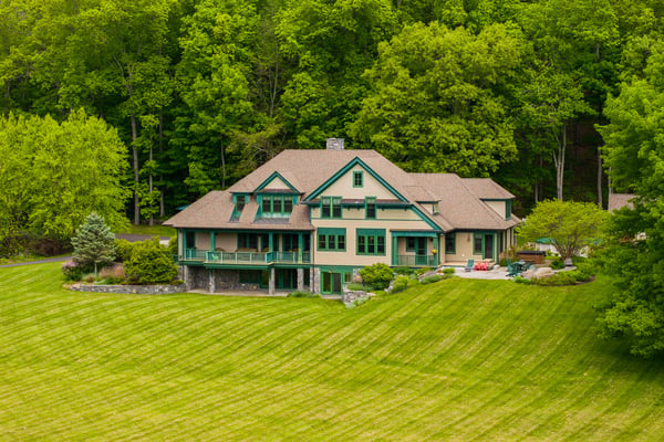 Nestled among lush greenery, this spacious home features expansive outdoor spaces and captivating architectural details.