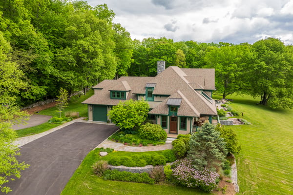 This well-designed home features a spacious layout, surrounded by lush greenery and ample outdoor space.