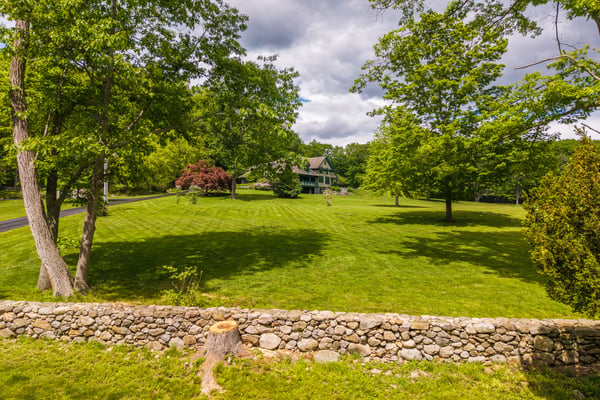 Spacious, verdant property featuring a welcoming home surrounded by mature trees and expansive lawns. Ideal for gatherings.