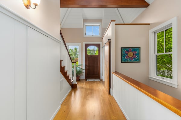 Discover a welcoming entryway featuring natural light, wood accents, and access to vibrant outdoor views.