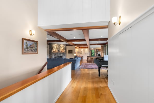 Spacious entryway featuring vaulted ceilings and wood accents, leading to an inviting living area with natural light.