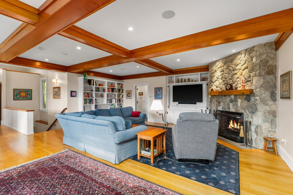 Spacious living area featuring a cozy fireplace, built-in shelves, and ample natural light throughout.