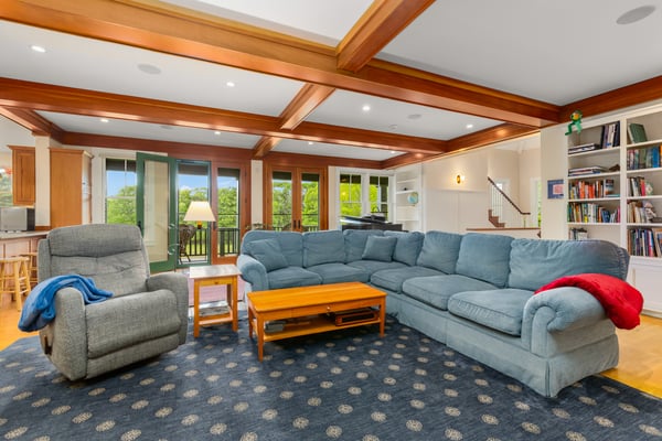 Spacious living area featuring a cozy sectional sofa, natural light, and easy access to outdoor views.