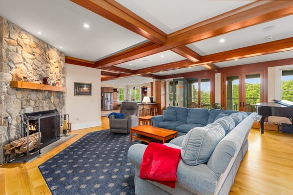 Spacious living area with a stone fireplace, large windows, and inviting atmosphere for gathering and relaxation.