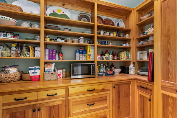 Spacious pantry featuring built-in shelving and ample storage for organized food and kitchen essentials.