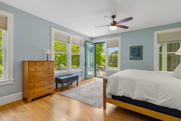 Bright and airy bedroom featuring large windows, direct access to outdoor space, and modern amenities.