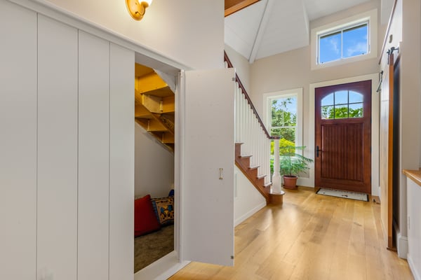 Bright and welcoming entryway featuring ample natural light, a cozy nook, and attractive wood finishes.