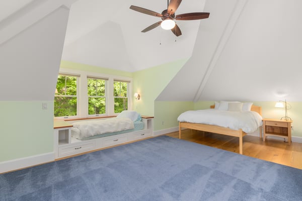 Spacious loft area featuring large windows, built-in seating, and ample room for relaxation and creativity.