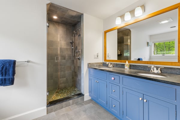 Spacious bathroom featuring a modern dual vanity, sleek shower, and ample natural light for a refreshing experience.