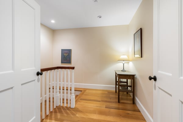 Bright and inviting landing featuring warm wood floors, a functional workspace, and soft ambient lighting.